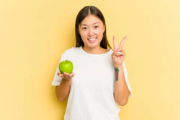 Jonge Aziatische Vrouw Eten Een Appel Geïsoleerd Gele Achtergrond Tonen — Stockfoto
