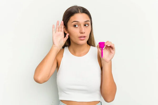 Młoda Kobieta Trzyma Kubek Menstruacyjny Odizolowany Białym Tle Próbując Słuchać — Zdjęcie stockowe