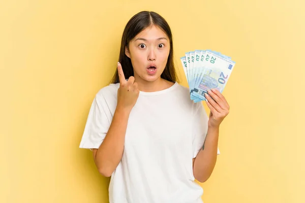 Young Asian Woman Holding Banknotes Isolated Yellow Background Having Some — Stock Photo, Image