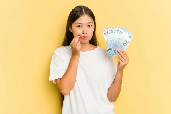 Young Asian Woman Holding Banknotes Isolated Yellow Background Fingers Lips — Stock Photo, Image
