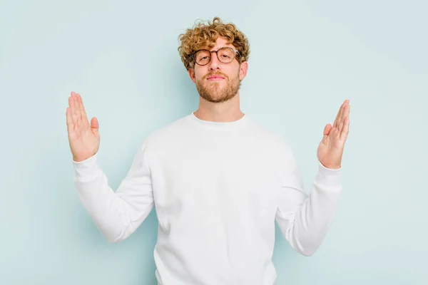 Young Caucasian Man Isolated Blue Background Holding Something Little Forefingers — Stock Photo, Image