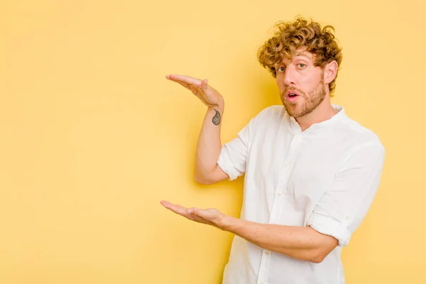 Ung Kaukasisk Man Isolerad Gul Bakgrund Chockad Och Förvånad Hålla — Stockfoto