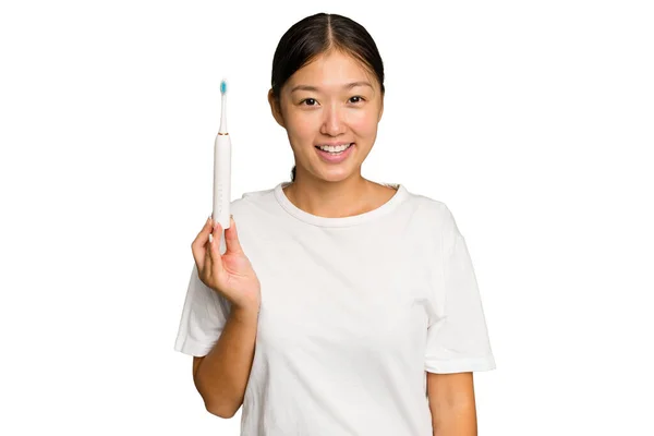 年轻的亚洲女人拿着用绿色背景隔开的电动牙刷 — 图库照片