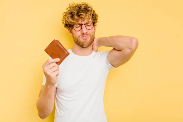 Young Caucasian Man Holding Wallet Isolated Yellow Background Touching Back — Stock Photo, Image