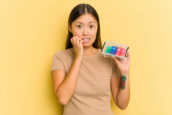 Junge Asiatin Die Batterien Hält Sie Isoliert Auf Gelbem Hintergrund — Stockfoto