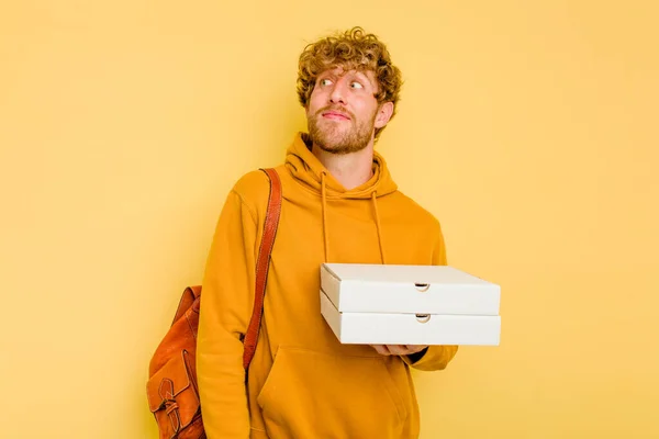 Młody Student Trzyma Pizzę Żółtym Tle Marząc Osiągnięciu Celów — Zdjęcie stockowe