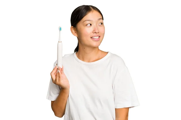 Junge Asiatin Mit Elektrischer Zahnbürste Isoliert Auf Grünem Farbhintergrund Blickt — Stockfoto