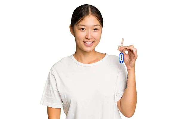 年轻的亚洲女人拿着家里的钥匙 与绿色的背景隔离 — 图库照片