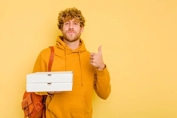 Młody Student Człowiek Gospodarstwa Pizze Izolowane Żółtym Tle Uśmiechając Się — Zdjęcie stockowe