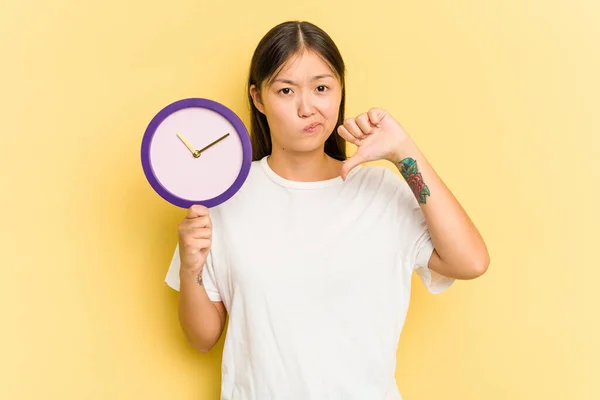 Mujer Asiática Joven Sosteniendo Reloj Aislado Sobre Fondo Amarillo Mostrando — Foto de Stock