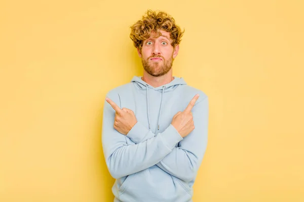Young Caucasian Man Isolated Yellow Background Points Sideways Trying Choose — Stock Photo, Image