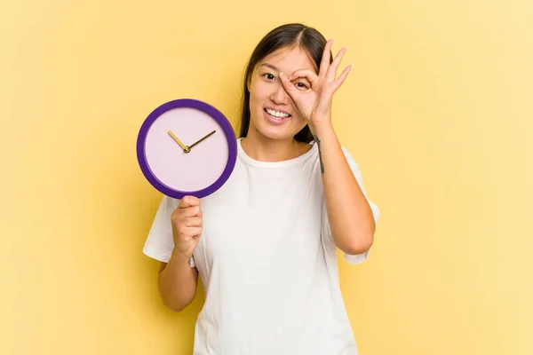Joven Asiático Mujer Celebración Reloj Aislado Amarillo Fondo Excitado Mantener — Foto de Stock