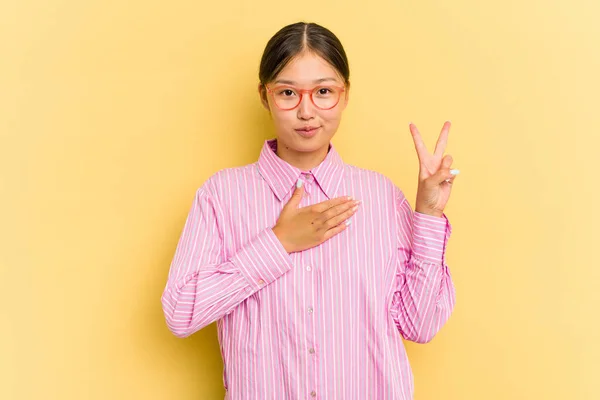 Jovem Mulher Asiática Isolada Fundo Amarelo Fazendo Juramento Colocando Mão — Fotografia de Stock