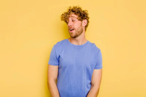 Young Caucasian Man Isolated Yellow Background Looks Aside Smiling Cheerful — Stock Photo, Image