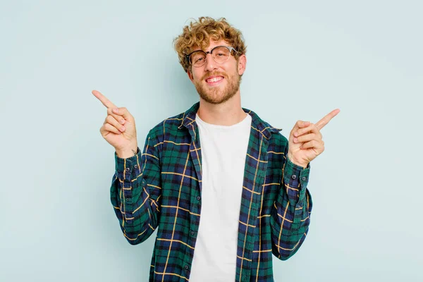 Joven Hombre Caucásico Aislado Sobre Fondo Azul Señalando Diferentes Espacios —  Fotos de Stock