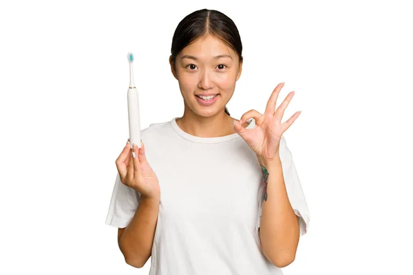 Junge Asiatische Frau Hält Eine Elektrische Zahnbürste Isoliert Auf Grünem — Stockfoto