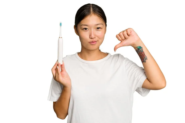 年轻的亚洲女人拿着一把绿色背景的电动牙刷 感到自豪和自信 可以学习 — 图库照片
