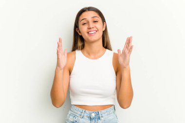 Beyaz arka planda izole edilmiş genç Hintli kadın yüksek sesle gülüyor elini göğsüne koyuyor..