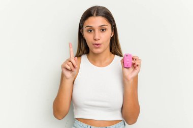 Genç Hintli kadın elinde pembe bir arabanın anahtarlarını tutuyor. Harika bir fikri var. Yaratıcılık kavramı..