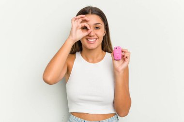 Genç Hintli bir kadın elinde elektronik pembe bir araba tutuyor. Anahtarlar heyecanlı..