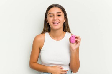 Genç Hintli kadın elinde pembe bir araba anahtarıyla gülüyor ve eğleniyor..