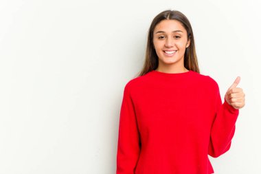 Genç Hintli kadın beyaz arka planda izole edilmiş gülümsüyor ve başparmağını kaldırıyor.