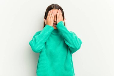 Beyaz arka planda izole edilmiş genç Hintli kadın yüzünün yarısını avuç içiyle kaplayarak eğleniyor..