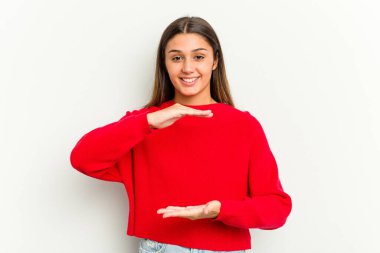 Beyaz arka planda izole edilmiş genç Hintli kadın iki eliyle bir şey tutuyor, ürün sunumu..