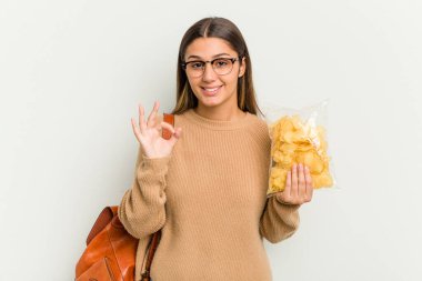 Genç Hintli kadın, beyaz arka planda izole edilmiş sakatları tutuyor. Neşeli ve kendinden emin..