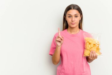 Sakatları beyaz arka planda tutan genç Hintli kadın bir numarayı parmaklarıyla gösteriyor..
