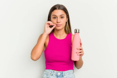 Beyaz arka planda pembe termosu olan genç Hintli kadın dudaklarında parmaklarıyla bir sır saklıyor..