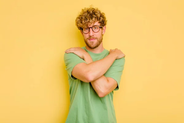 Joven Hombre Caucásico Aislado Los Abrazos Fondo Amarillo Sonriente Despreocupado — Foto de Stock