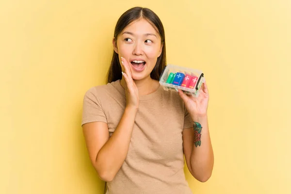 電池を持っている若いアジアの女性は 黄色の背景叫びと口を開いた近くに手のひらを保持上に隔離リサイクル — ストック写真