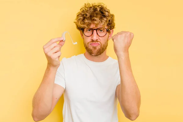 Jonge Blanke Man Met Gehoorapparaat Geïsoleerd Gele Achtergrond Met Vuist — Stockfoto