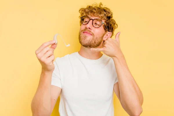 Junger Kaukasischer Mann Mit Hörgerät Auf Gelbem Hintergrund Der Eine — Stockfoto