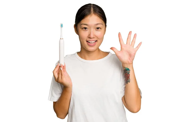 Junge Asiatin Mit Elektrischer Zahnbürste Auf Grünem Hintergrund Fröhlich Lächelnd — Stockfoto
