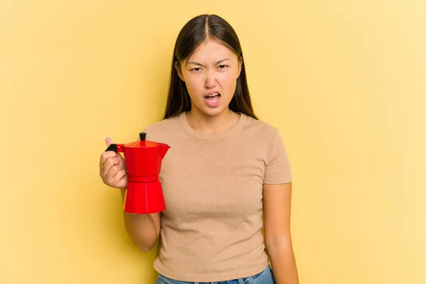 Sarı Arka Planda Izole Edilmiş Kahve Makinesini Tutan Genç Asyalı — Stok fotoğraf