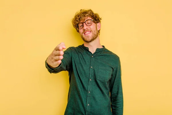 Joven Hombre Caucásico Aislado Sobre Fondo Amarillo Estirando Mano Cámara — Foto de Stock