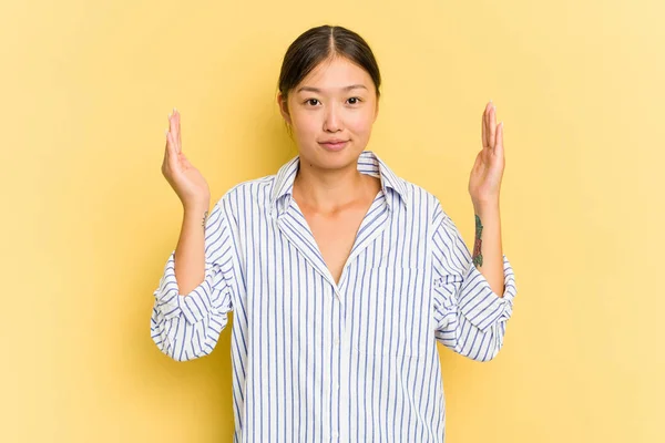 Young Asian Woman Isolated Yellow Background Holding Something Little Forefingers — Stock Photo, Image