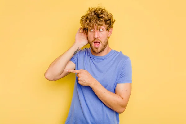 Joven Hombre Caucásico Aislado Sobre Fondo Amarillo Tratando Escuchar Chisme — Foto de Stock