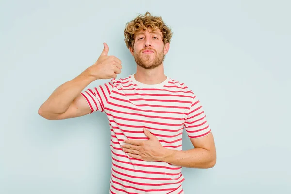 Jonge Blanke Man Geïsoleerd Blauwe Achtergrond Raakt Buik Glimlacht Zachtjes — Stockfoto