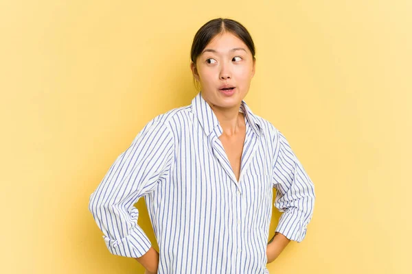 Young Asian Woman Isolated Yellow Background Looks Aside Smiling Cheerful — Stock Photo, Image