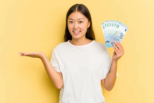 Young Asian Woman Holding Banknotes Isolated Yellow Background Showing Copy — Stock Photo, Image