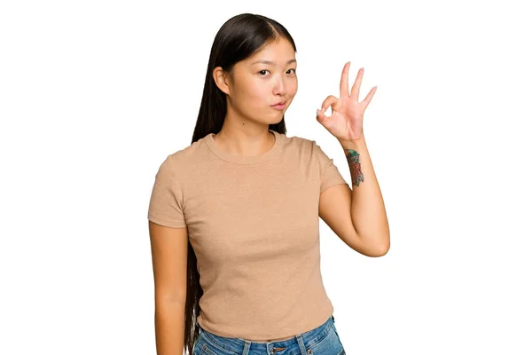 被绿色背景隔离的年轻亚洲女人眨了眨眼 用手握住一个好的手势 — 图库照片