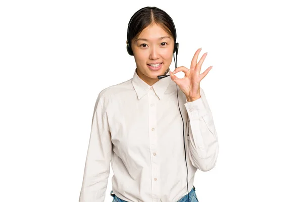 テレマーケティングアジアの女性作業とともにヘッドセット隔離オン緑色の背景陽気で自信を持ってショーOkジェスチャー — ストック写真