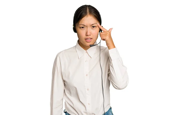 用绿色背景隔离的耳机工作的亚洲女人用食指表示失望的姿态 — 图库照片