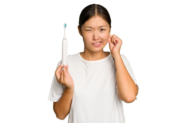 年轻的亚洲女人 手拿着用绿色彩色背景隔开耳朵的电动牙刷 — 图库照片