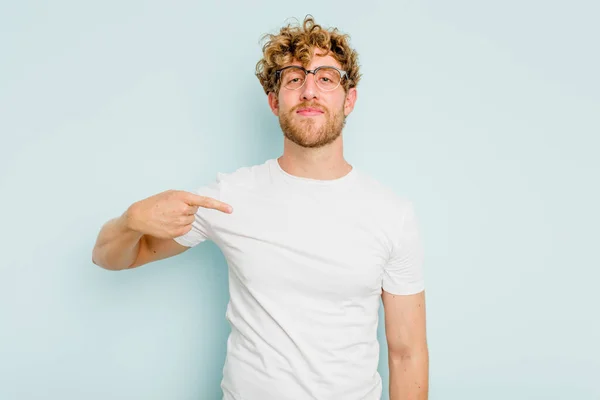 Mladý Běloch Izolovaný Modrém Pozadí Osoba Ukazuje Ručně Košili Kopírovací — Stock fotografie