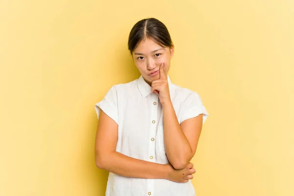 年轻的亚洲女人在黄色背景下孤立无援 思考着策略 思考着做生意的方式 — 图库照片