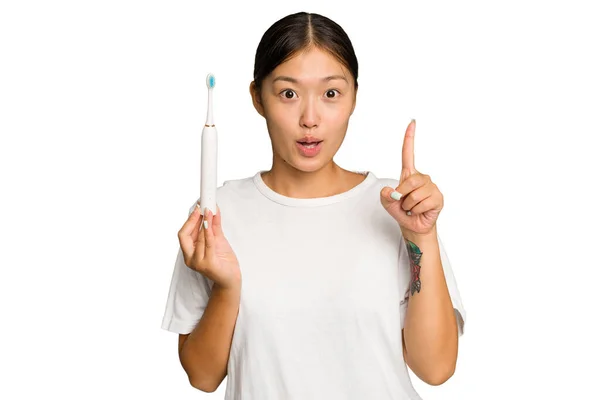 緑のクロマの背景に孤立した電動歯ブラシを持っている若いアジアの女性は いくつかの素晴らしいアイデア 創造性の概念 — ストック写真